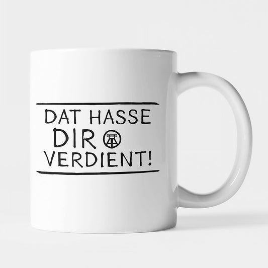 Weiße Keramiktasse mit schwarzem Ruhrpott-Spruch 'Dat hasse dir verdient!', beidseitig bedruckt.