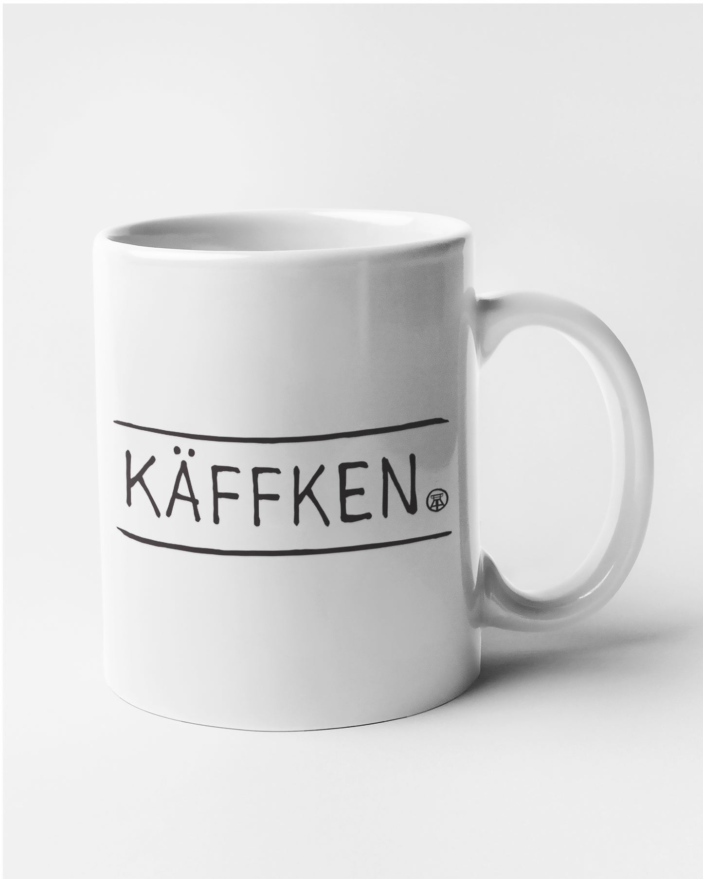Weiße Tasse mit handgezeichnetem 'KÄFFKEN'-Design – ideal als Geschenk oder für den täglichen Gebrauch.