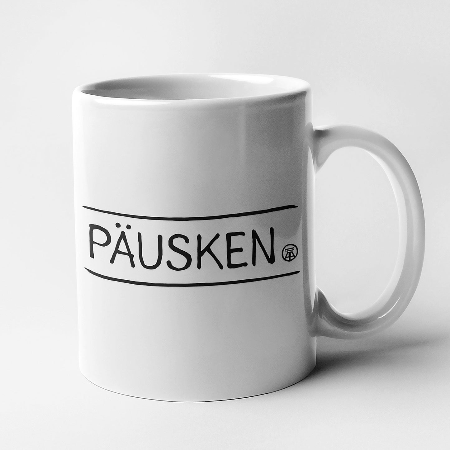 Schlichte Tasse mit schwarzem Schriftzug 'PÄUSKEN' – perfekt für Kaffee, Tee oder als Geschenk.