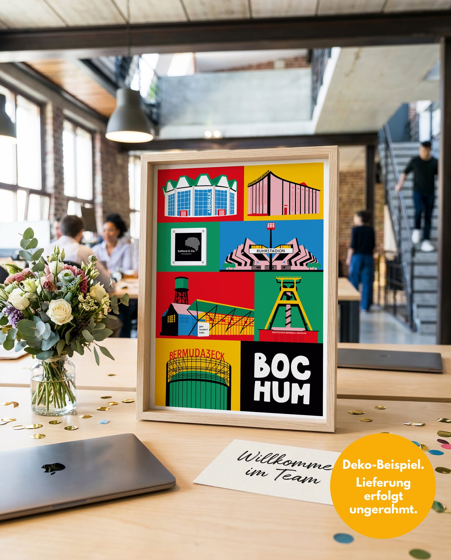 Onboarding Geschenk Einzug Büro: Personalisiertes Bochum Poster mit Firmenlogo neben einer Willkommenskarte und Blumen auf einem Schreibtisch.