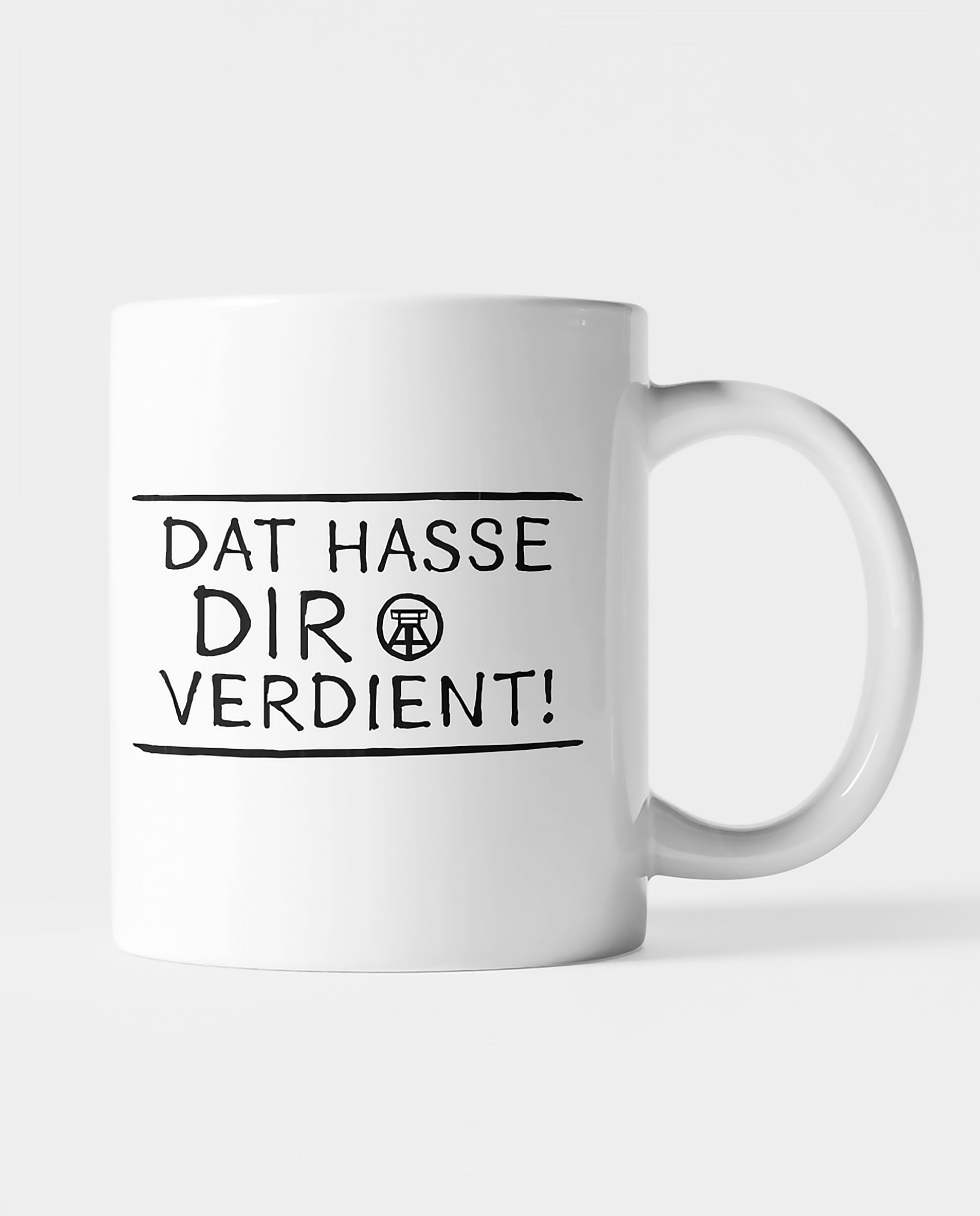 Weiße Keramiktasse mit schwarzem Ruhrpott-Spruch 'Dat hasse dir verdient!', beidseitig bedruckt.