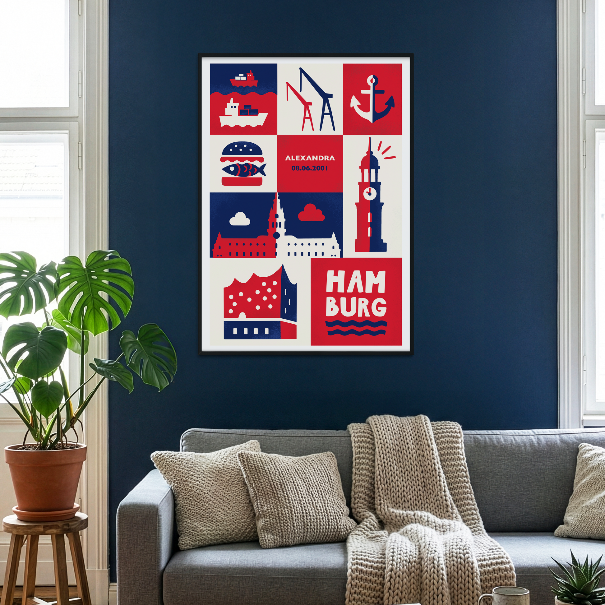 Personalisierbares Hamburg Poster mit Name und Datum im Wohnzimmer mit dunkelblauer Wand, grauem Sofa und gemütlicher Hygge-Einrichtung. Kunstdruck mit Elbphilharmonie, Michel und Hafenmotiven in Rot, Blau und Creme.