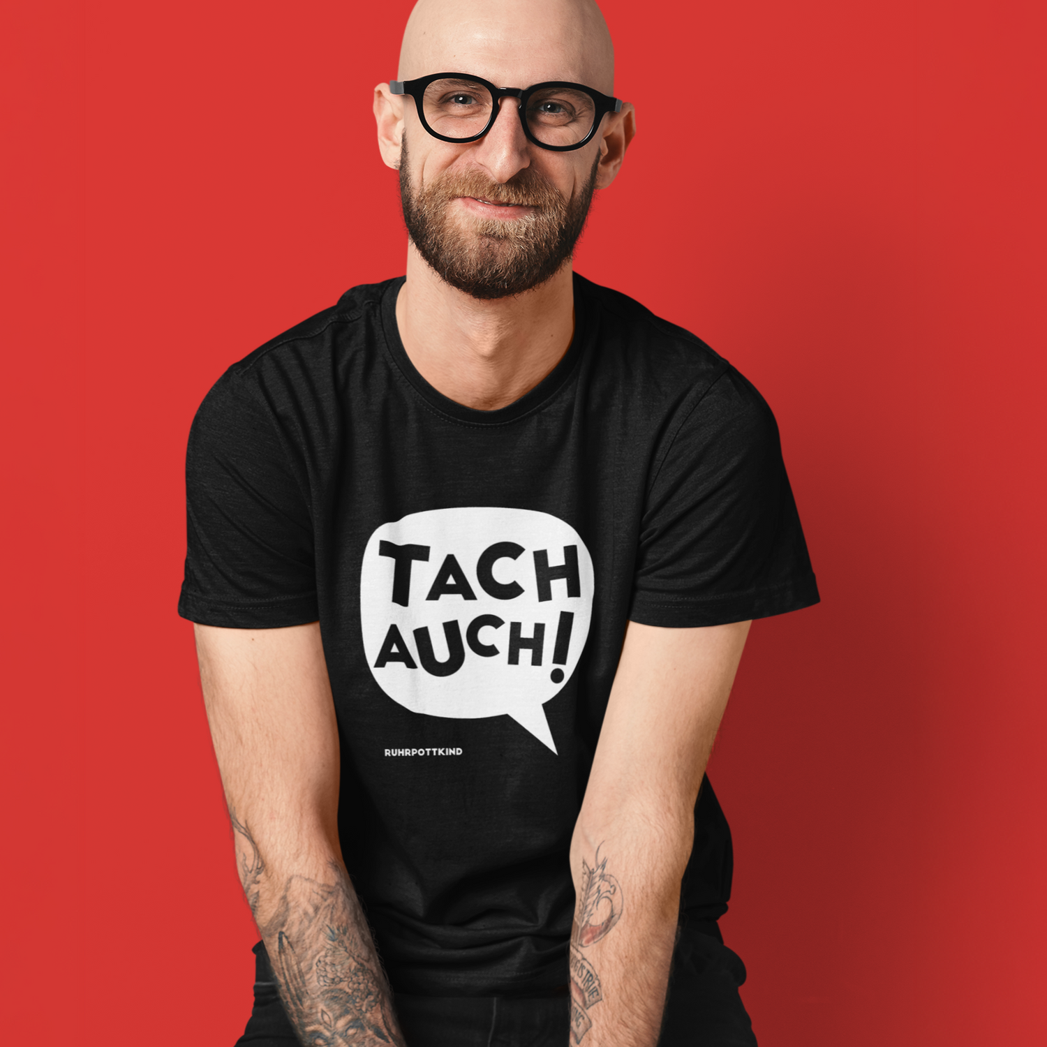 Zwei T-Shirts mit witzigem Ruhrpott-Gruß „Tach auch!“ in auffälligem Comic-Stil, erhältlich in Schwarz und Rot.