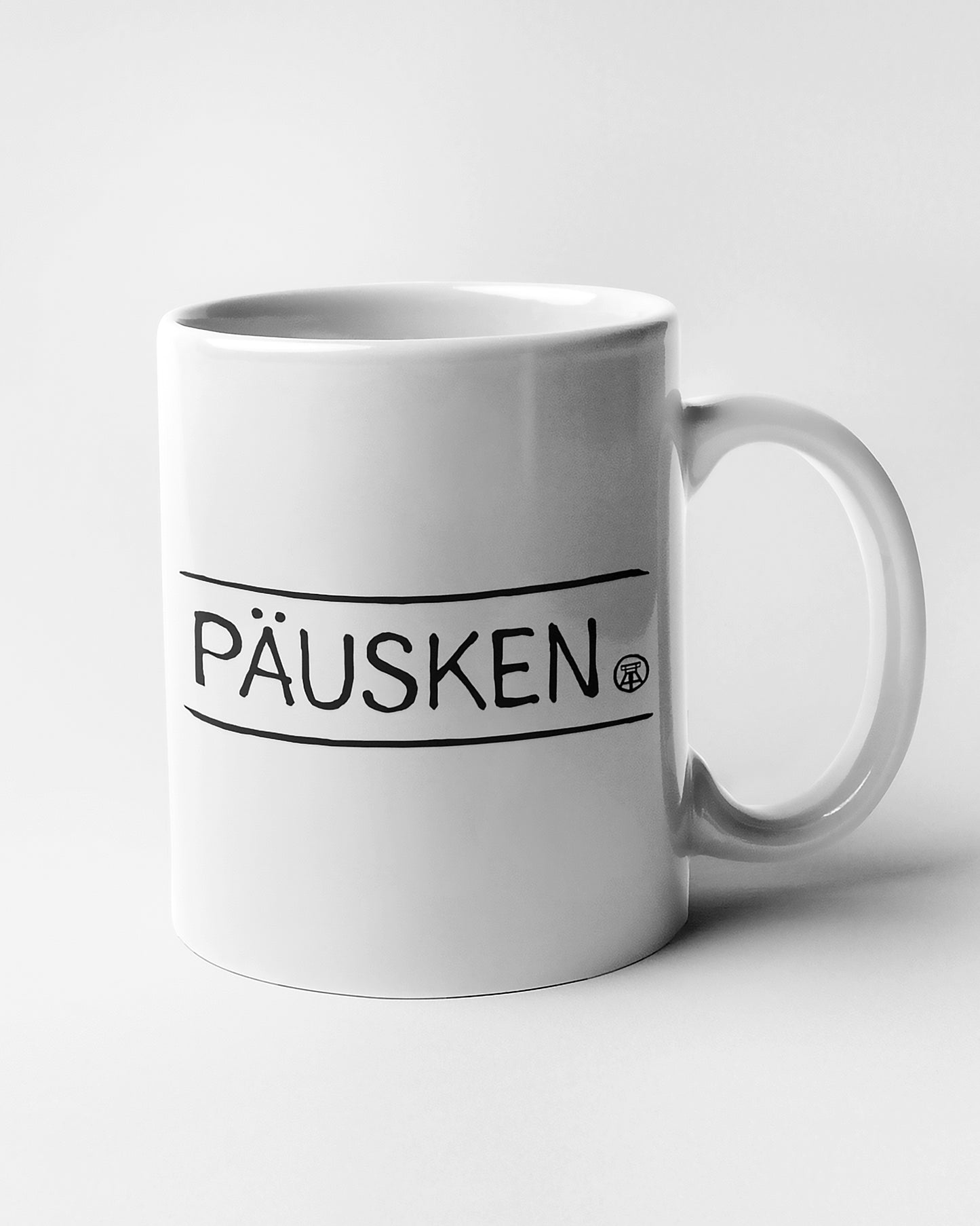 Schlichte Tasse mit schwarzem Schriftzug 'PÄUSKEN' – perfekt für Kaffee, Tee oder als Geschenk.